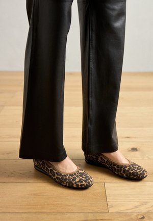 Leopardmønstrede balletflade med en blød overdækning, rund tå og fleksibel sål, parret med sorte læder brede bukser.