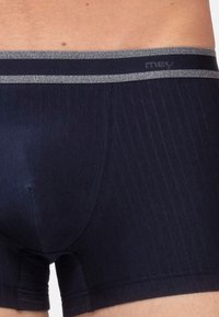 Mörkblå boxershorts i ett mjukt tyg med ett grått elastiskt midjeband som har en diskret logotyp och vertikala ränder.