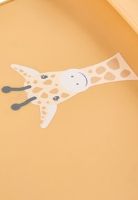 Gelber Hintergrund mit einer Cartoon-Giraffe, die orangefarbene Flecken, ein lächelndes Gesicht, schwarze Antennen und einfache Augen hat.