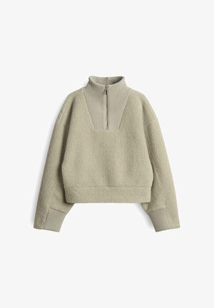 Hellgrüner, cropped Sweater aus einem weichen, flauschigen Material. Verfügt über einen hohen Kragen mit einem halben Reißverschluss sowie gerippten Akzenten am Saum und an den Bündchen.