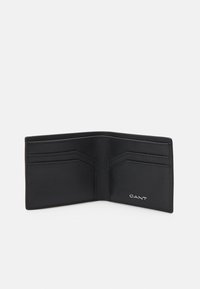 Black leather wallet with multiple card slots, smooth texture, and a metallic brand logo embossed on the lower right corner.
