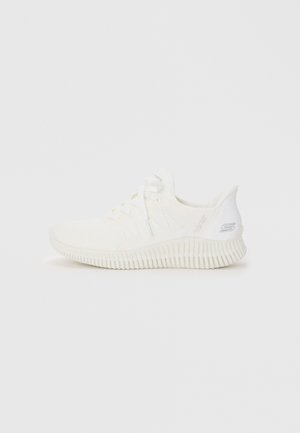 White athletic shoe with a textured knit upper, lace-up front, and a thick, ridged white rubber sole. Minimal detailing and smooth finish.