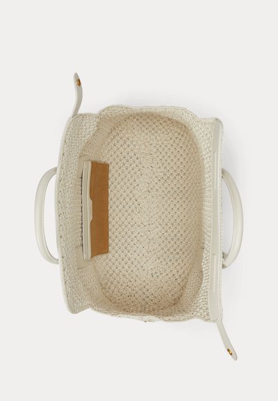 Fehér bőr fogantyúkkal és egy kis barna bőr belső zsebbel ellátott szőtt krémszínű táska, felülről fehér háttéren bemutatva.