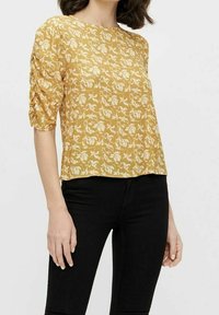 Haut à manches courtes jaune moutarde avec motif floral blanc, en tissu léger, doté de manches froncées et d'une coupe décontractée.