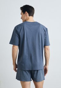 Blauwe katoenen t-shirt met korte mouwen en een ronde hals, gecombineerd met bijpassende blauwe katoenen shorts. Glad materiaal, casual pasvorm.