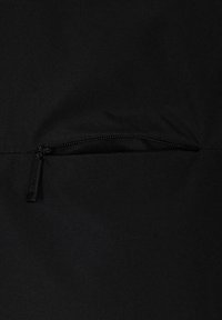 Il tessuto nero presenta una tasca con zip, con una texture liscia e un design minimalista. Il tirante della zip è piatto e rettangolare.