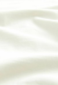 Tissu doux de couleur crème avec une texture lisse, affichant de délicates plis et un léger éclat typiques d'un mélange de coton léger ou de polyester.