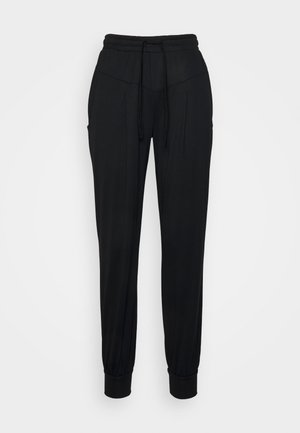 Jogging noir en tissu doux, avec une taille élastique et un cordon de serrage, deux poches latérales et des poignets resserrés aux chevilles.