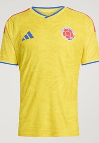 Maillot de football jaune avec bordure bleue, bandes rouges aux épaules, logo Adidas et emblème de l'équipe nationale de football de Colombie sur la poitrine.