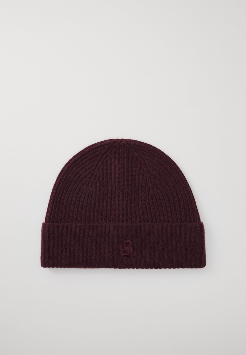 Burgundijas adīta beanie cepure ar ribotu tekstūru un salocītu maliņu, kas priekšpusē rotāta ar izreljefētu logotipu.