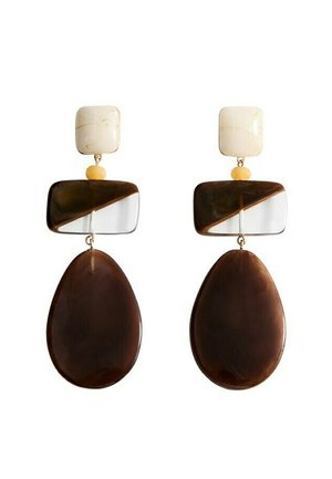 Orecchini con parti superiori quadrate color crema, piccoli perline gialle, blocchi rettangolari metà marroni e metà trasparenti, e pendenti a goccia grandi marroni.