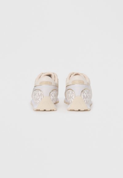 Baskets de sport beiges avec un dessus à texture et un motif de logo, des accents en maille et une semelle ridée de couleur beige clair.