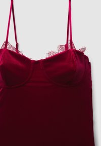 Camisole en satin bordeaux avec bretelles réglables et bordure en dentelle le long du décolleté. Caractérisée par un corsage ajusté et une texture lisse.