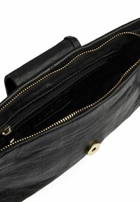 Svart läderväska med en slät yta, dragkedjestängning, detaljer i guldton och ett inre fack för organisering.