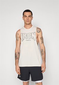 Light beige sleeveless tank top with black "IRON Paradise" graphic, paired with dark shorts featuring a white hem and logo detail.