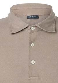 Polo color beige con tessuto testurizzato, colletto e tre bottoni. Presenta un'etichetta con "MAERZ" sotto il colletto.