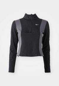 Tricou cu mânecă lungă, cu fermoar la gât, de culoare neagră și gri, cu un design ajustat și logo-ul Nike, având panouri laterale contrastante și o textură netedă.