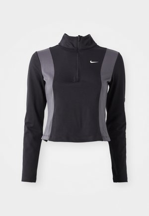 Haut à manches longues noir et gris à zip quart avec un design ajusté et le logo Nike, présentant des panneaux latéraux contrastants et une texture lisse.