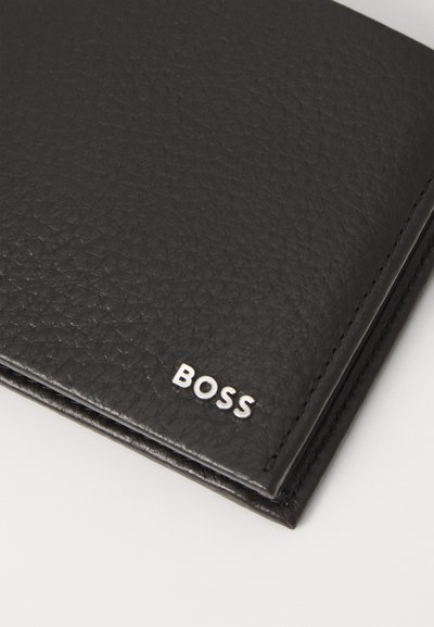 Portefeuille en cuir noir avec une surface texturée, des bords cousus et un logo "BOSS" en argent dans le coin inférieur.