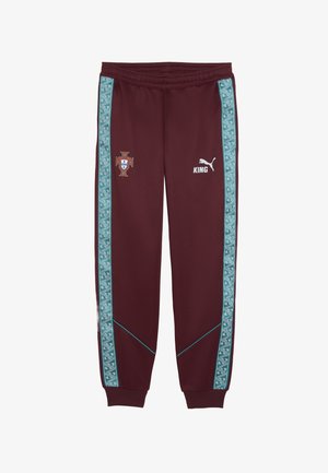 Pantalon de survêtement marron avec des bandes à motifs bleu sarcelle, emblème du Portugal sur la cuisse gauche, et logo Puma blanc avec "KING" sur la cuisse droite.