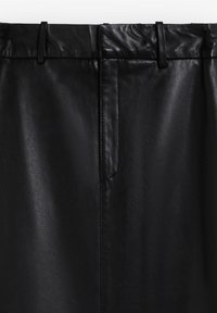 Falda de cuero sintético negra con una textura suave, una cinturilla estructurada con trabillas para cinturón y un bolsillo lateral discreto.