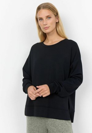 Must mustaga pikka varrukaga sviiter, ümar kaelus, lahti istuv ja soonikkoes. Omab sileda tekstuuri ja peeneid külgsidemeid hem'i juures.