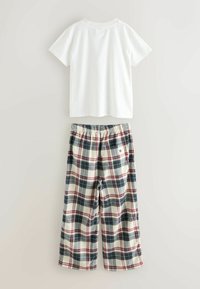 Biela bavlnená tričko v kombinácii s károvanými pyžamovými nohavicami v krémovej, námorníckej a burgundskej farbe. Nohavice majú elastický pás a bočné vrecká.