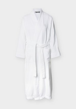 Beli kopalni plašč do kolen z dolgimi rokavi, šal ovratnikom, dvema sprednjima žepoma in pasom za zavezovanje na enobarvni podlagi.