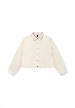 Chemise cropped en crème, fabriquée dans un tissu lisse, dotée d'un devant à boutons, d'une poche poitrine et de poignets élastiques sur des manches longues.
