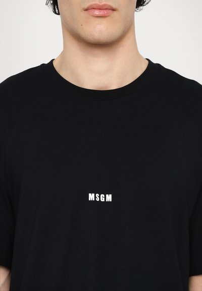 Black cotton t-shirt with a crew neckline. Features a white "MSGM" logo centered on the chest. Short sleeves, standard fit.