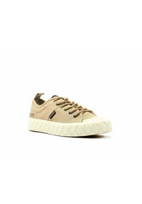 Beige Leinensneaker mit runder Spitze, strukturierter weißer Gummisohle und braunen Schnürsenkeln. Mit schwarzem Branding an der Seite und einer Zuglasche an der Ferse.