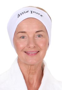 Weißes Handtuch-Stirnband mit "âme pure" in schwarzem Stick, getragen mit einem weißen Gewand; glatte Textur und einfaches, sauberes Design.