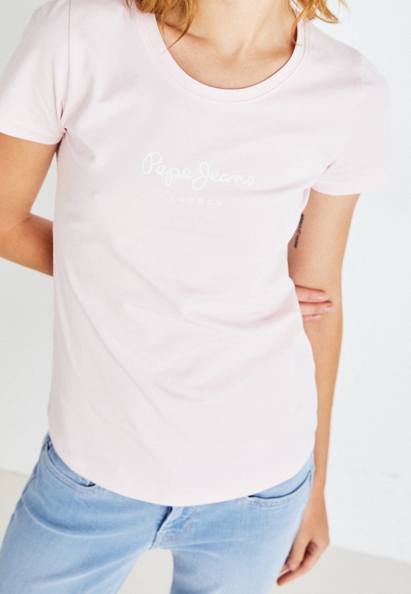 Světle růžové tričko s krátkým rukávem z měkké bavlny, s logem "Pepe Jeans London" bílé barvy přes hruď. Volný střih.