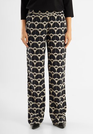 Wide-leg trousers in a black fabric featuring a cream arched pattern. The waistband is elastic, and they have a smooth texture.