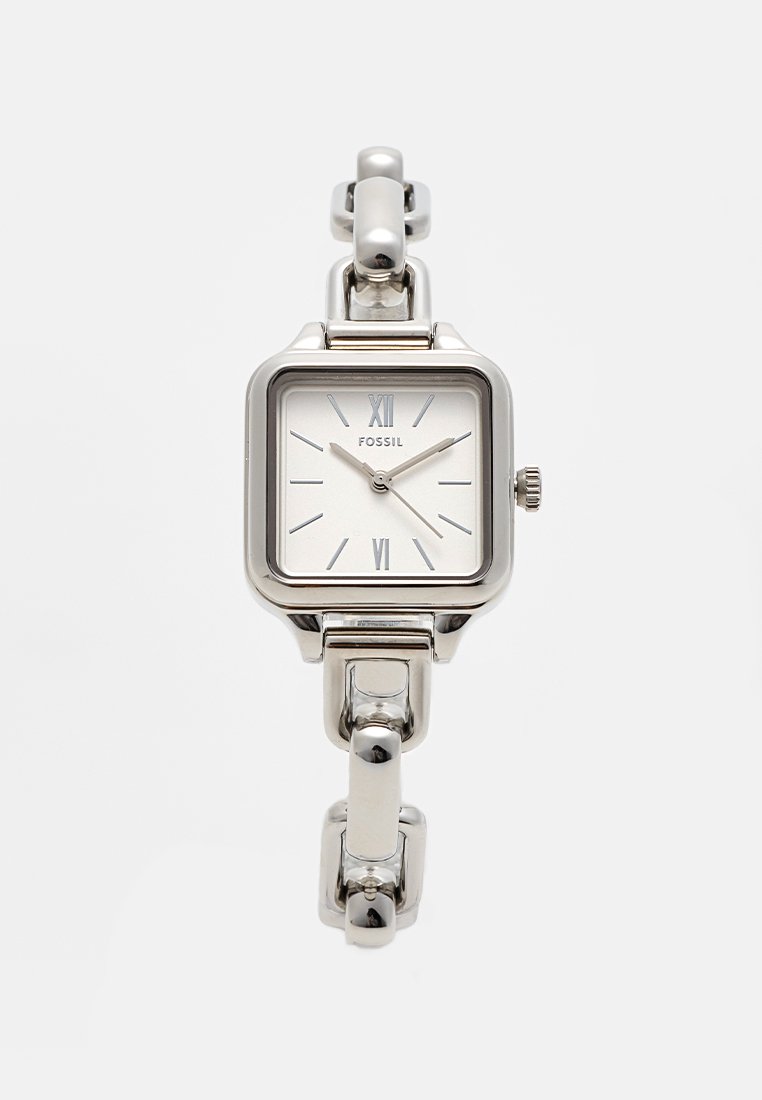 Orologio Fossil rettangolare argento con quadrante bianco, numeri romani e bracciale metallico a maglia con finiture lucide e una superficie testurizzata.