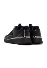 Sneakers neri con materiale sintetico liscio, dettagli testurizzati, dettaglio del tallone nero lucido e suola nera spessa. Presentano una linguetta.