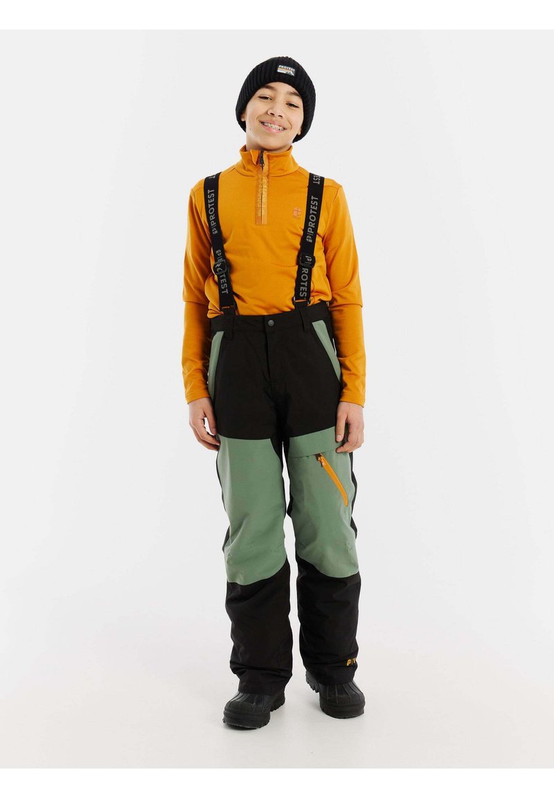 Maglia arancione a maniche lunghe con cerniera, pantaloni da sci verdi e neri con bretelle regolabili, vita elastica e tasca laterale con cerniera. Stivali neri.