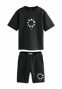 Černá bavlněná sada trička a šortek s kulatým bílým logem a textem "SAINT LAURENT LONDON" na obou kusech. Neformální design, jemná textura.