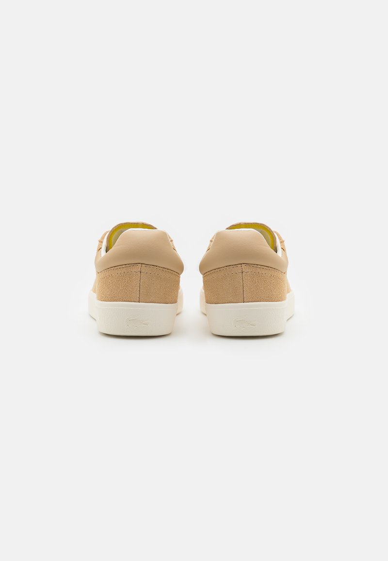 Zapatillas de cuero y ante color marrón claro con suela blanca; presentan un diseño de corte bajo y acentos texturizados en el talón.