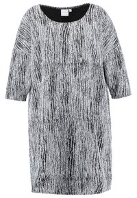 Robe texturée noire et blanche, longueur genou, avec des manches trois-quarts et un col rond.