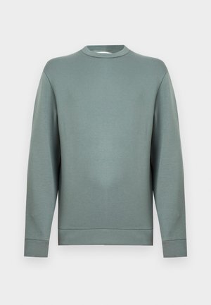 Svijetlo zelena majica okruglog izreza s dugim rukavima, izrađena od mekanog tkanina, s jednostavnim dizajnom i rebrastim manšetama i rubom.