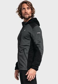 Gray and black zip-up jacket with a hood, made of soft, textured fabric, featuring a zippered pocket and logo detail on the sleeve.