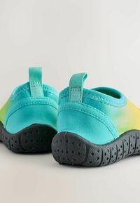 Scarpe da acqua slip-on con gradiente aquamarina e giallo, suole in gomma nera testurizzata e tiranti in tessuto arretrati per una facile vestibilità.