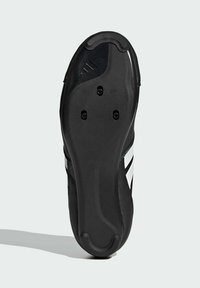 Svart sul på sko med en slät yta, försänkta områden för grepp och tre cirkulära hål för fäste av dobbar. Randiga detaljer nära sidan.