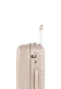 Maleta rígida en beige claro, con superficie texturizada, asa retráctil, asa lateral y cerradura de combinación.