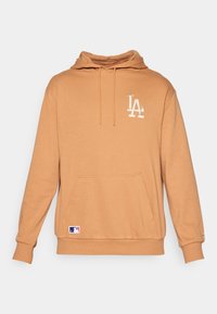 Haut à capuche en tissu beige, avec une poche kangourou sur le devant, un capuchon avec cordon de serrage et un logo LA brodé en blanc. Patch logo MLB sur l'ourlet.