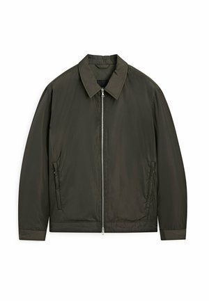 Veste zippée vert foncé avec un col, deux poches latérales et une texture légèrement rembourrée. Tissu lisse au design minimaliste.