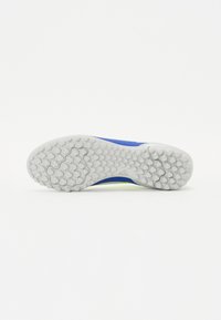 Blå atletiske sko med en struktureret hvid gummisål, der har hexagonale mønstre og et lavprofil design.