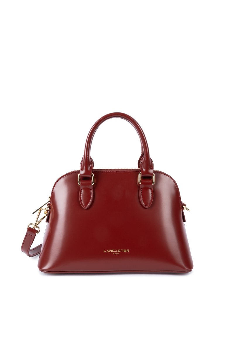 Borsa a mano in pelle rossa lucida con due manici arrotondati, dettagli in metallo dorato e spallacci rimovibili. Presenta una chiusura con zip.