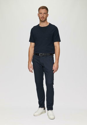 Granatowy t-shirt typu crew-neck z kieszonką, zestawiony z granatowymi chinosami slim fit i białymi trampkami. Gładki materiał, casualowy design, minimalistyczne akcenty.
